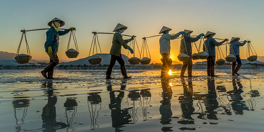 People carrying baskets on beach
