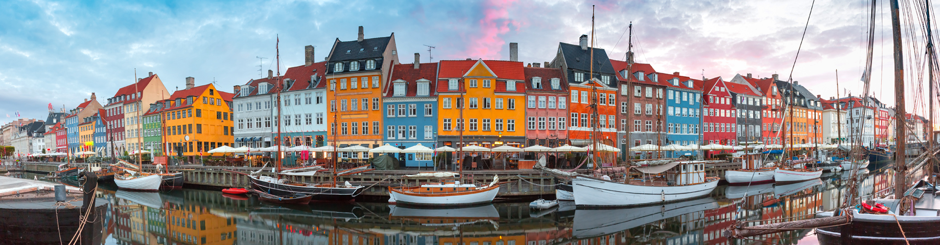 Canal with boats on it and houses behind