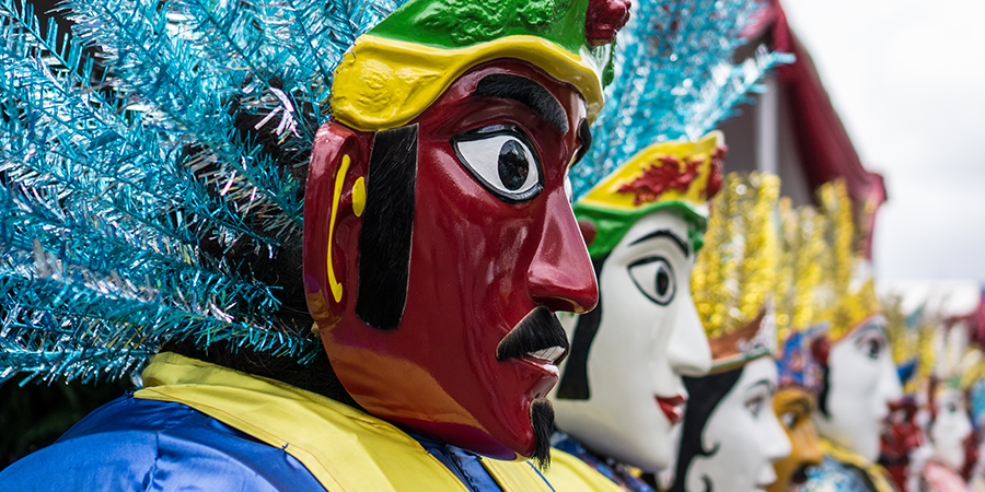 People wearing cultural masks in Indonesia