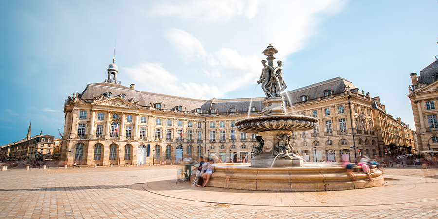 People sitting next to fountain in square